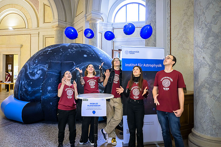Gruppe von jungen Wissenschafter*innen vor dem Pop-up Planetarium auf der Sternwarte